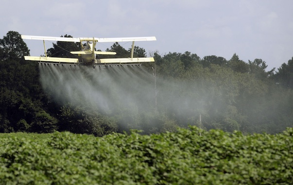An aerial applicator sprays a field. Oregon regulators are proposing a rule to limit the use of chlorpyrifos. (Associated Press photo)
