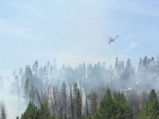 (Kimberlee Kruesi photo) A helicopter flies over the #210 Road Fire near Redfish Lake Tuesday, July 23.