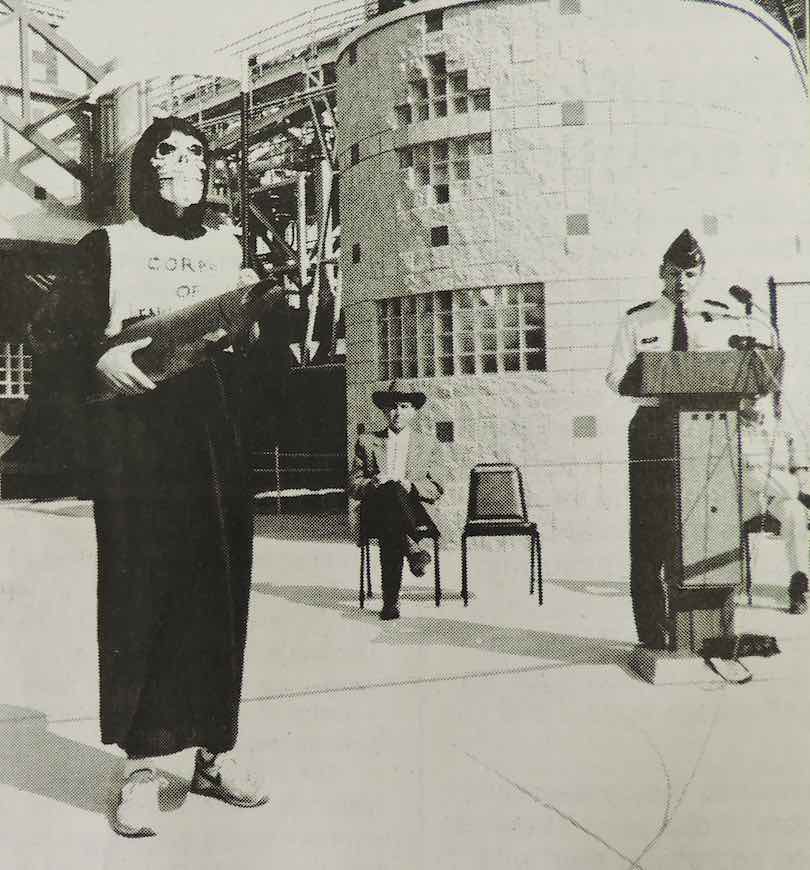 A protester expresses his grim view of McNary Dam's juvenile fish facility as the dam's commander, Lt. Col. James Weller, officiates at its opening ceremony in 1994.
