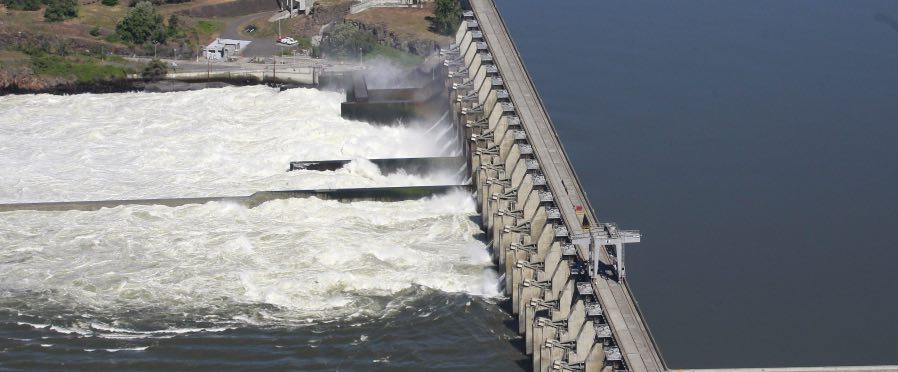 Water flows through The Dalles Dam on the Columbia River, in The Dalles, Ore. A federal judge recently ruled that The Army Corps of Engineers must provide additional spill at eight federal dams along the Columbia and Snake Rivers this spring. The spill will aid out-migrating juvenile spring Chinook headed to the ocean. An appeal is pending. (Rick Bowmer/The Associated Press)