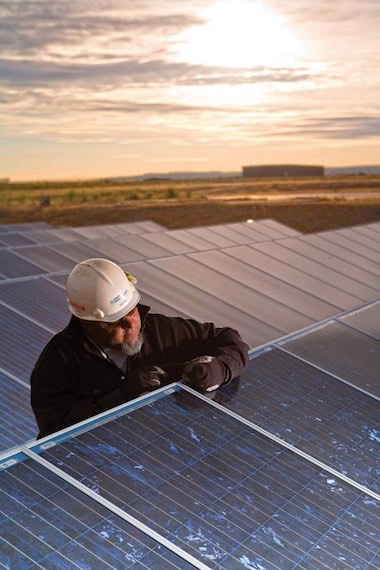 A worker checks solar panels at the White Bluffs Solar Station near Richland. A French firm is set to build a new solar station near the site. File Caren Brinkema