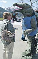 (Brian Wallace/Juneau Empire) Vicki Pigott, left, a passenger on the cruise ship Norwegian Sun listens to Sarah Lemagie in a king salmon suit talk about the attributes of Alaska wild salmon during the, Wild Alaska Salmon Celebration sponsored by the Southeast Alaska Conservation Council at Marine Park Wed. Pigott who eats wild salmon caught in waters off of Scotland and Alaska said, 'Farmed salmon is not very good.'
