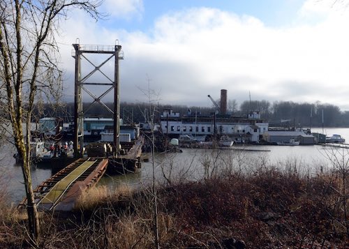 Coast Guard responders from Sector Columbia River Incident Management Division begin a proactive cleanup effort of the barge Multnomah, which is moored at a site along the Columbia River, Goble, Ore., Feb. 2, 2016. The Coast Guard opened the Oil Spill Liability Fund to remove hazardous materials, from the Multnomah a 265-foot barge, in order to mitigate a substantial threat to the environment.