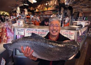 (Steve Ringman) Pike Place Fish Market owner John Yokoyama holds a 30-pound Copper River king salmon. The fish is considered sustainable, and Yokoyama aims to make the rest of the business fit that definition by January. But even figuring out exactly what that means can be a challenge.