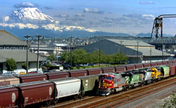 (Bruce Kellman) A BNSF Railway train with four engines and 116 cars heads northwest from the Port of Tacoma between the Thea Foss Waterway and Schuster Parkway.