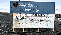 A tatered sign reads, United States Department of Energy, Hanford Site, RESTRICTED GOVERNMENT AREA.