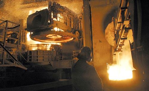 (Ellen M. Banner photo) The lid on the electric arc furnace at Nucor steel mill is lifted up so more metal can be dropped into the furnace to be melted. Sixty thousand tons of scrap metal are melted there each month. Demand from China and the economic recovery in the United States have re-energized some Pacific Northwest metal industries.