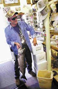 Huck Eckes, of Devil's Lake, North Dakota, proudly displays a 13.5-pound Salmon that he caught earlier in the day. Eckes, who has fished for salmon almost everywhere that a person can, considers himself a 'fishing machine.'