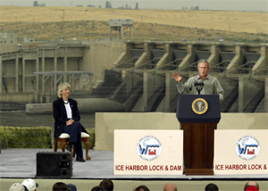 (AP: Ted S. Warren) President Bush speaks at the Ice Harbor Lock and Dam near Burbank, Wash. Friday, Aug. 22, 2003 as Secretary of the Interior Gale Norton looks on at left. Bush was in the state to address environmental and salmon issues. 