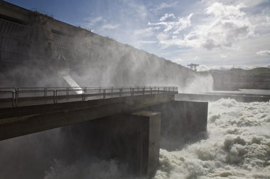 (Jamie Francis) Water powers through the spillway at The Dalles Dam. Two years ago, the Army Corps of Engineers spent $51.3 million to build an 850-foot-long wall just past the spill outlets -- the light-gray wall in the background -- to divert young migrating fish from predators, smallmouth bass and pikeminnow that congregate in shallow water just downstream. The wall helped boost juvenile salmon and steelhead survival at the dam to more than 90 percent.